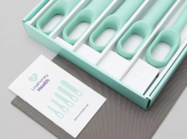 a set of five pastle green silicone dilators in a cardboard box, with a silver storage bag under it. A booklet sits next to the dilators.